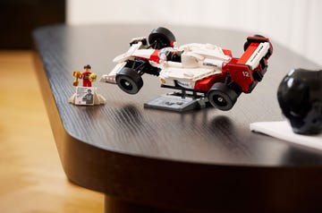 lego icons set featuring f1 mclaren car, shown fully assembled with ayrton senna minifigure on a wooden table