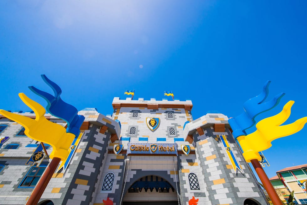 entrance to a castlethemed hotel with colorful banners and flags