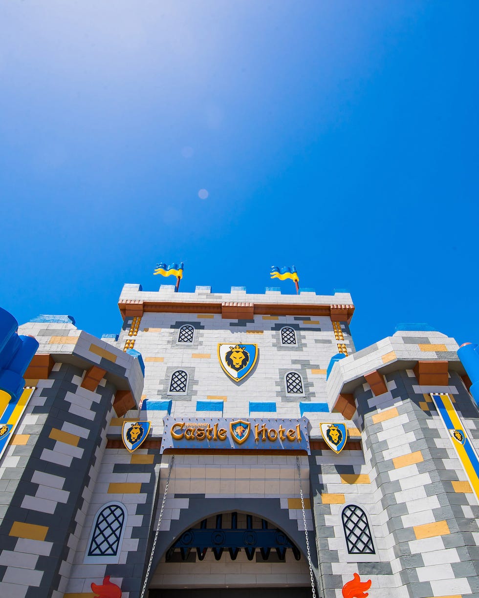 entrance to a castlethemed hotel with colorful banners and flags