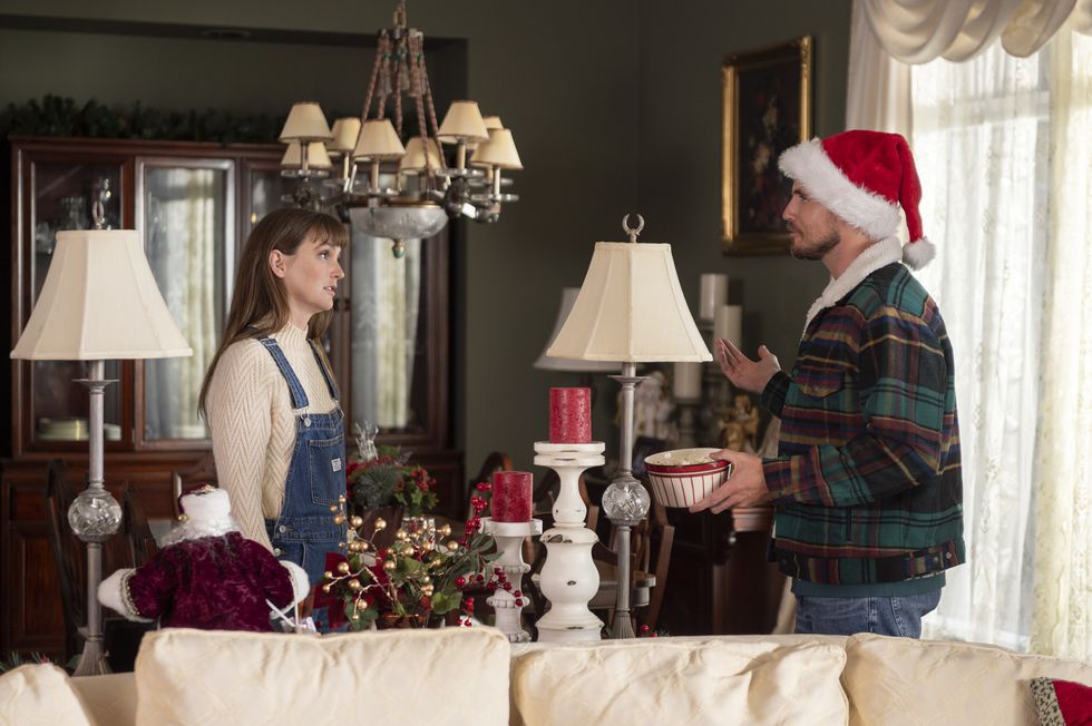 leighton meester y robbie amell protagonizan exmas, una pareja joven se encuentra en una sala de estar en Navidad discutiendo