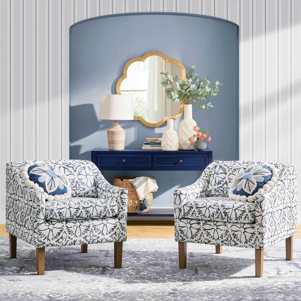 two patterned armchairs next to a console table with decorative items