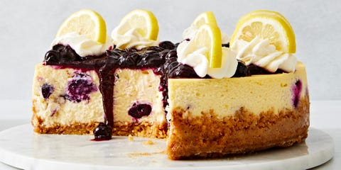 lemon blueberry cheesecake topped with a jammy blueberry topping, whipped cream and lemon slices