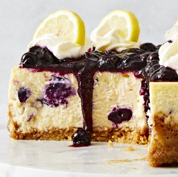 lemon blueberry cheesecake topped with a jammy blueberry topping, whipped cream and lemon slices