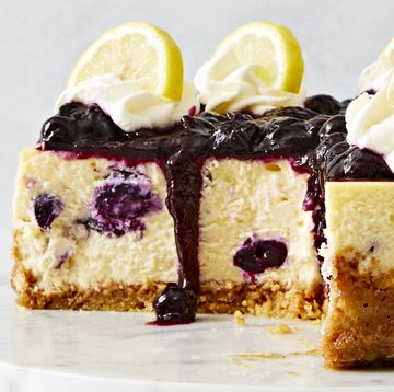 lemon blueberry cheesecake topped with a jammy blueberry topping, whipped cream and lemon slices