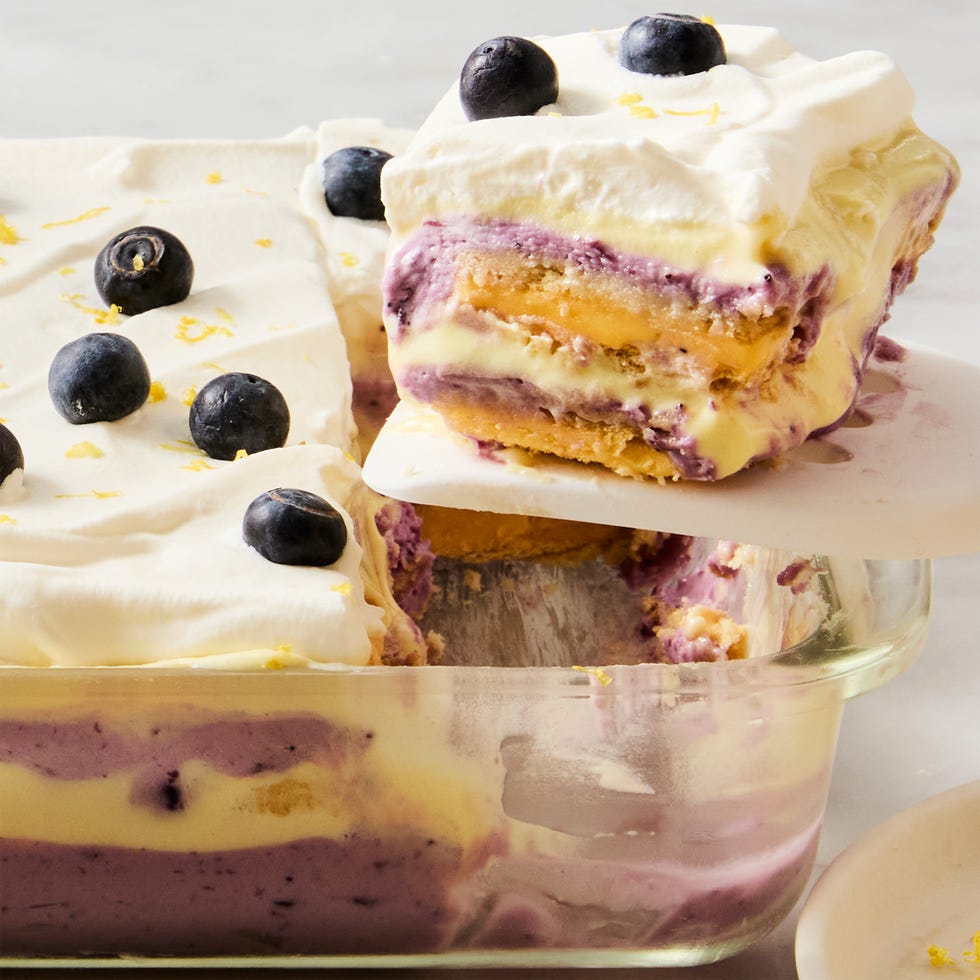 layers of lemon, blueberry, and cheesecake in a casserole dish topped with fresh blueberries