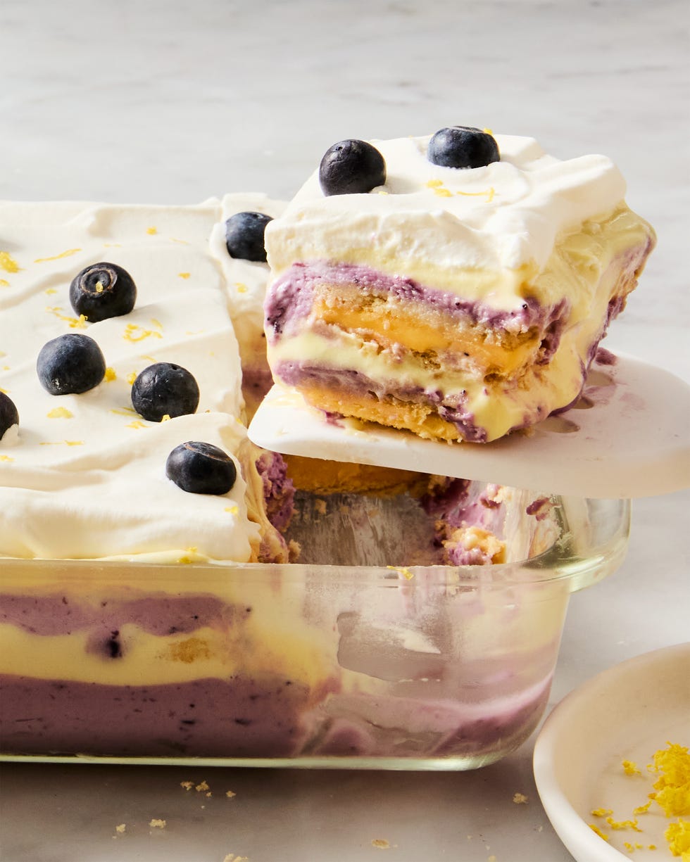 layers of lemon, blueberry, and cheesecake in a casserole dish topped with fresh blueberries