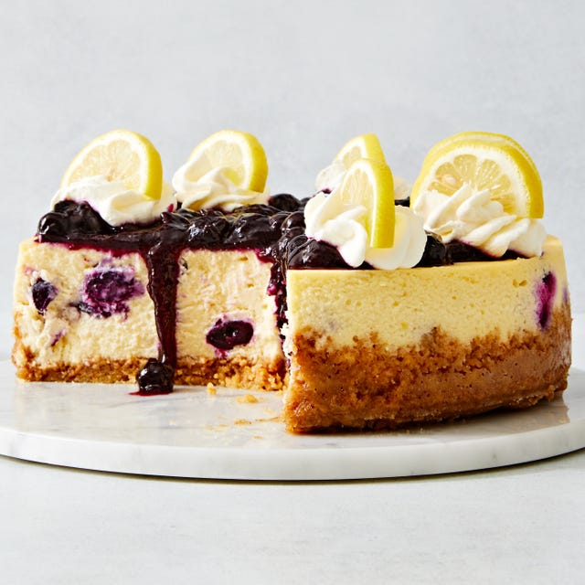 lemon blueberry cheesecake topped with a jammy blueberry topping, whipped cream and lemon slices
