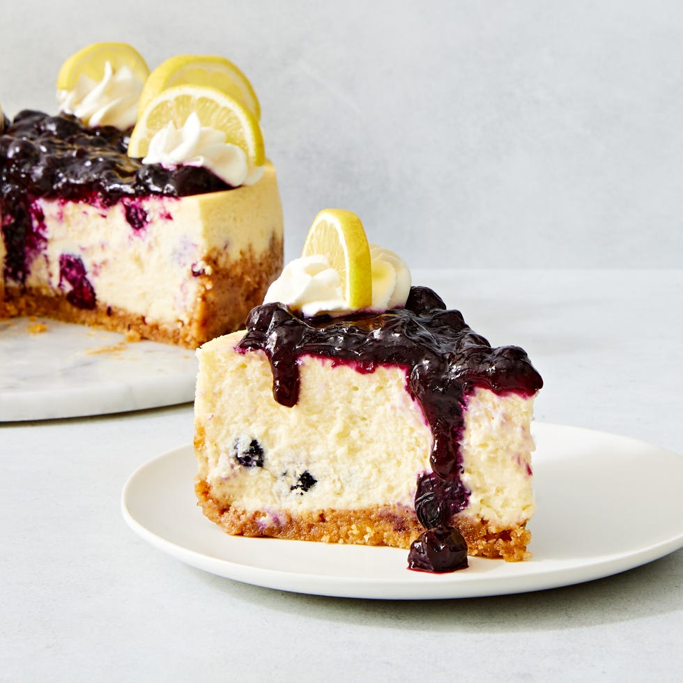 lemon blueberry cheesecake topped with a jammy blueberry topping, whipped cream and lemon slices