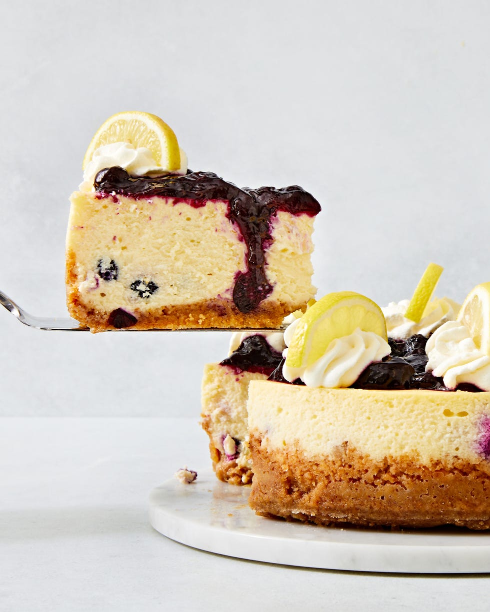 lemon blueberry cheesecake topped with a jammy blueberry topping, whipped cream and lemon slices
