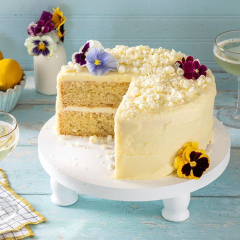 a lemon cake with white chocolate curls and fresh flowers