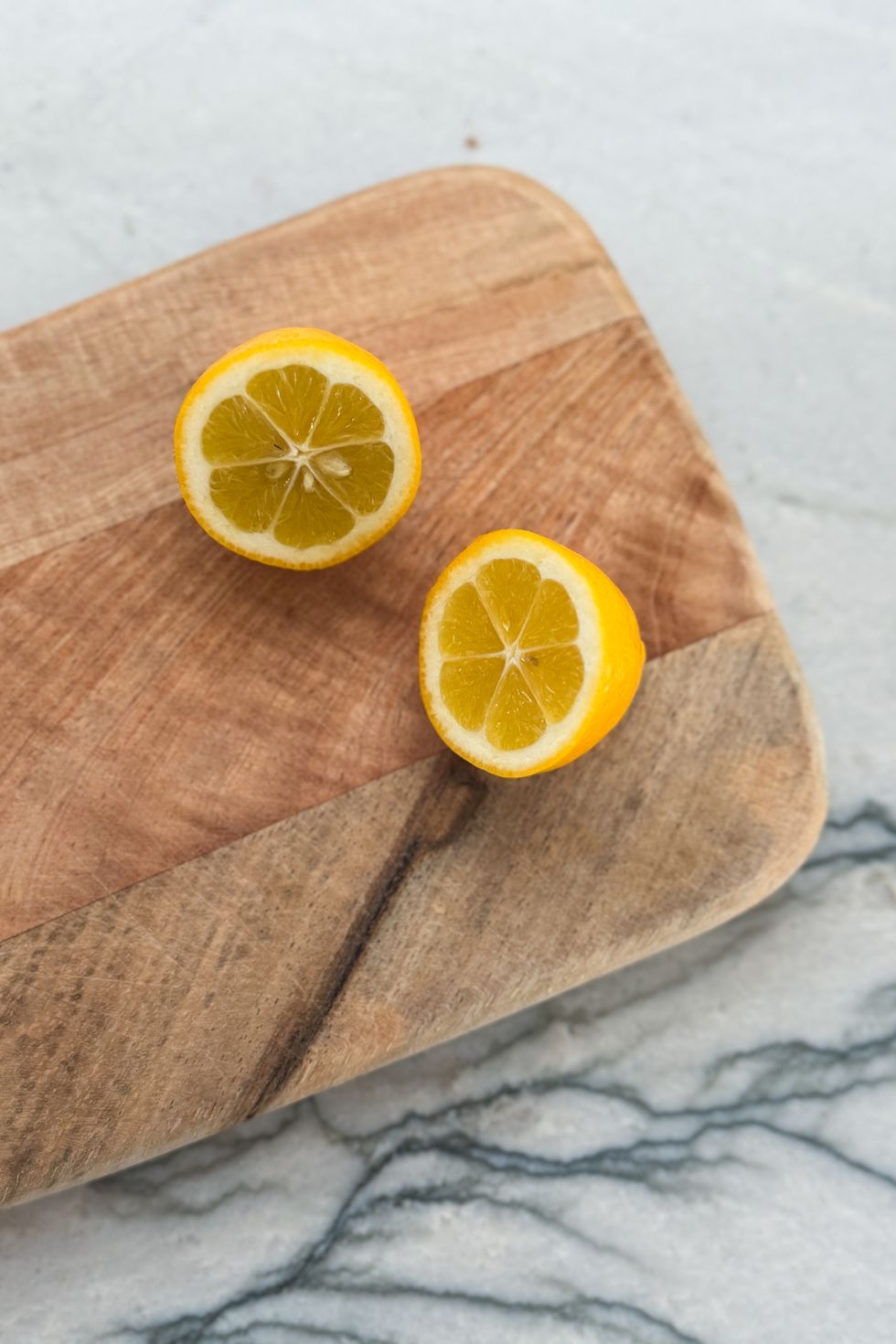 lemon halves on a wooded cutting board still life stock photo