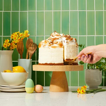 lemon meringue cheesecake on a wooden cake stand