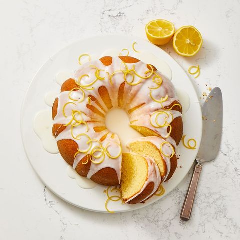 a round lemon pound cake with icing and shavings of lemon zest on top