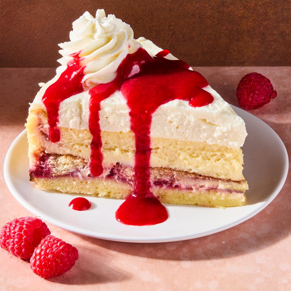 cake and cheesecake layers topped with lemon mousse, cheesecake, and raspberry syrup