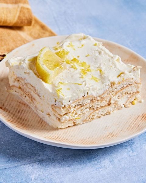 square slice of lemon icebox cake on an off white plate on a blue background