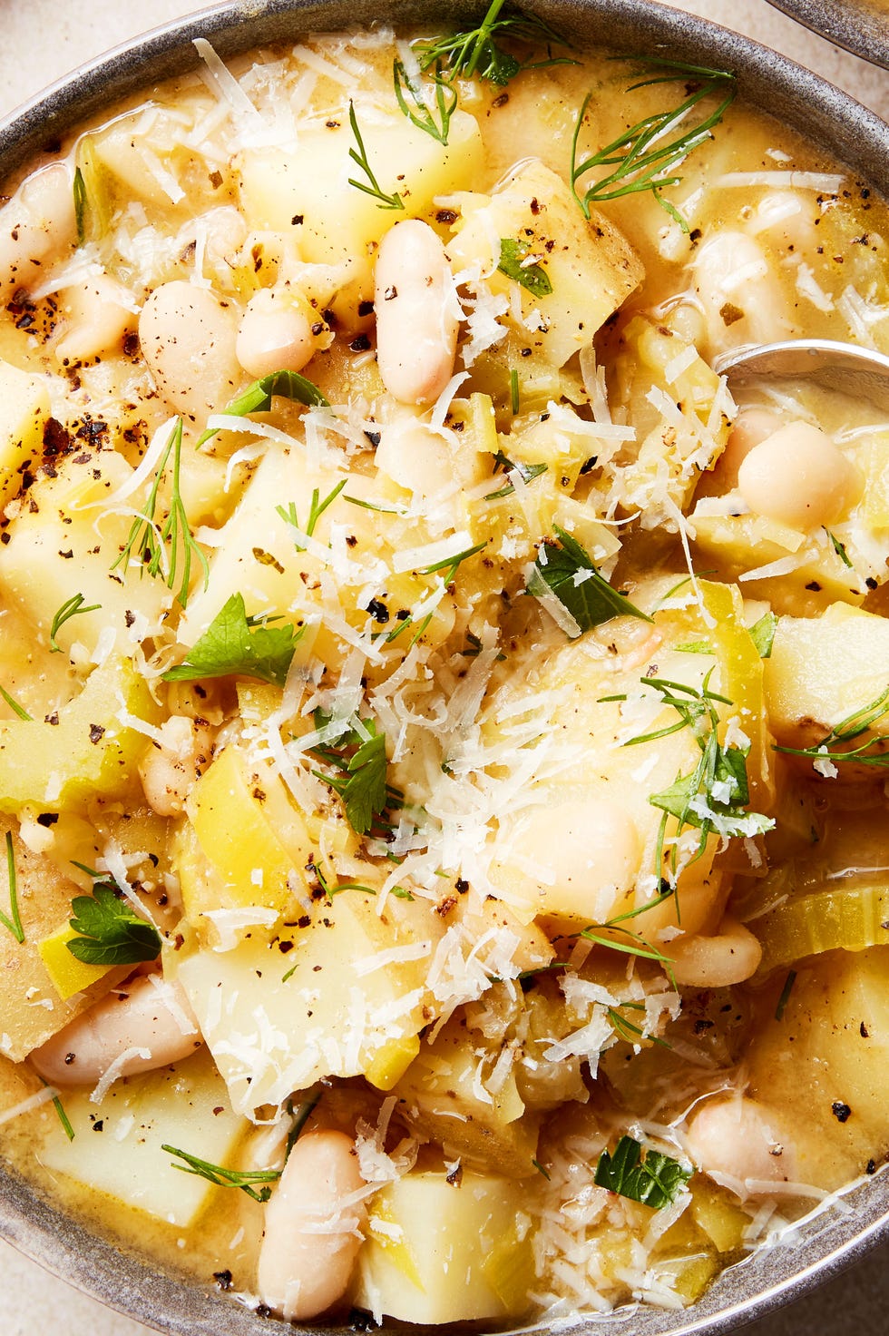 Lemony White Bean & Potato Soup white beans and potatoes in a soup topped with parmesan
