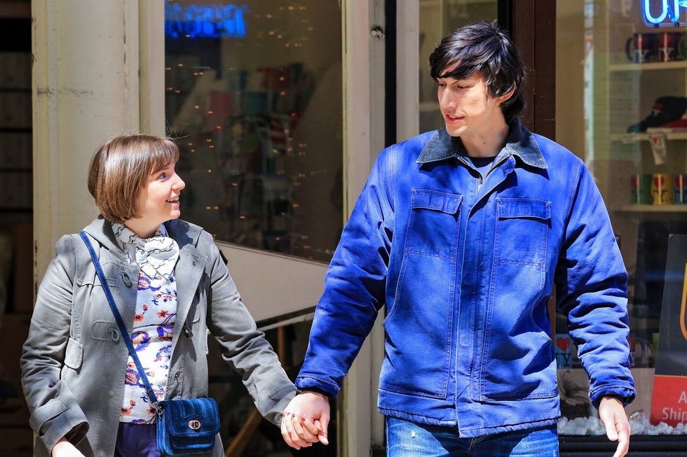 lena dunham and adam driver hold hands and look at each other on a city street