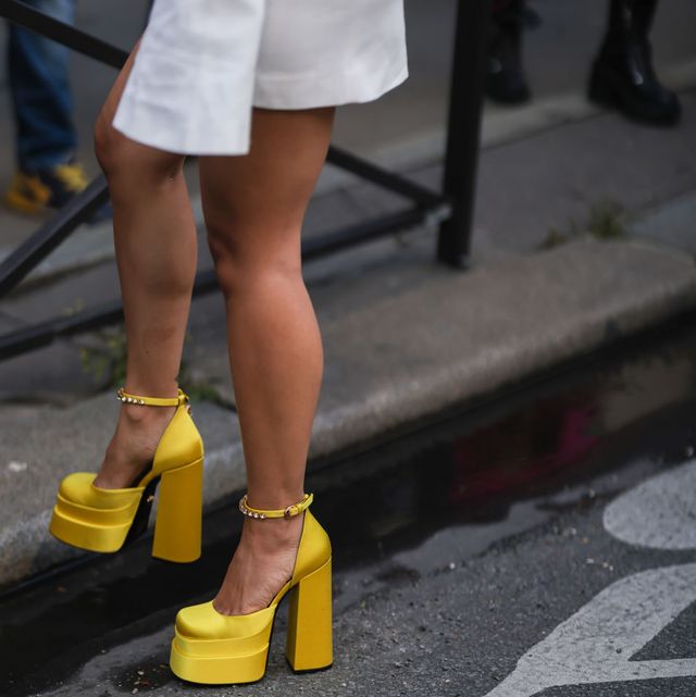 a woman at paris fashion week wears versace's platform heels in bright yellow