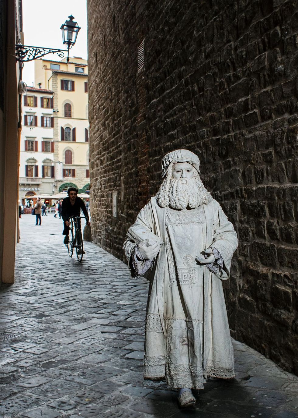In Florence verwierf de jonge Da Vinci bekendheid vanwege zijn buitengewone talent in de stad kreeg hij zijn eerste opdrachten Hij was een trofee en een statussymbool voor opdrachtgevers zegt museumdirecteur Paolo Galluzzi Hier belichaamt straatartiest Valter Conti de sterrenstatus van Da Vinci hij loopt naar het museum Uffizi om op de foto te gaan met toeristen