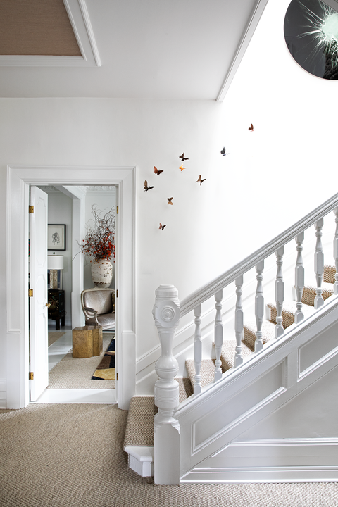 white room with butterfly sculptures going up staircase