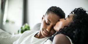 couple at home snuggling under blanket