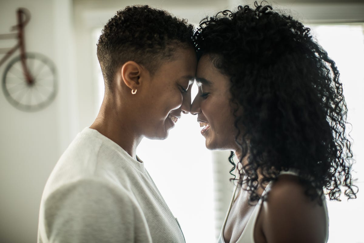 lesbian couple embracing at home