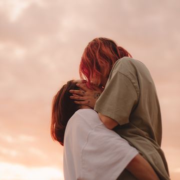 lesbian couple kissing at sunset during summer