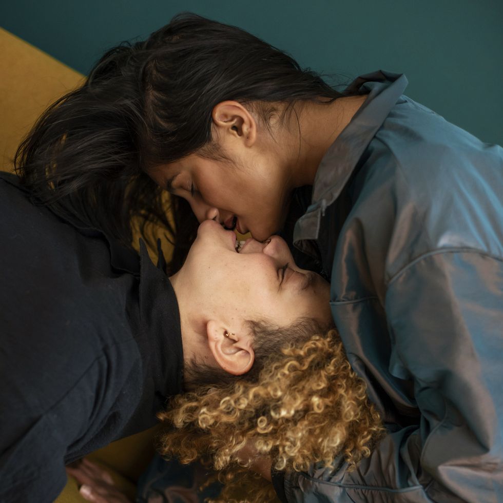 lesbian couple kissing on sofa