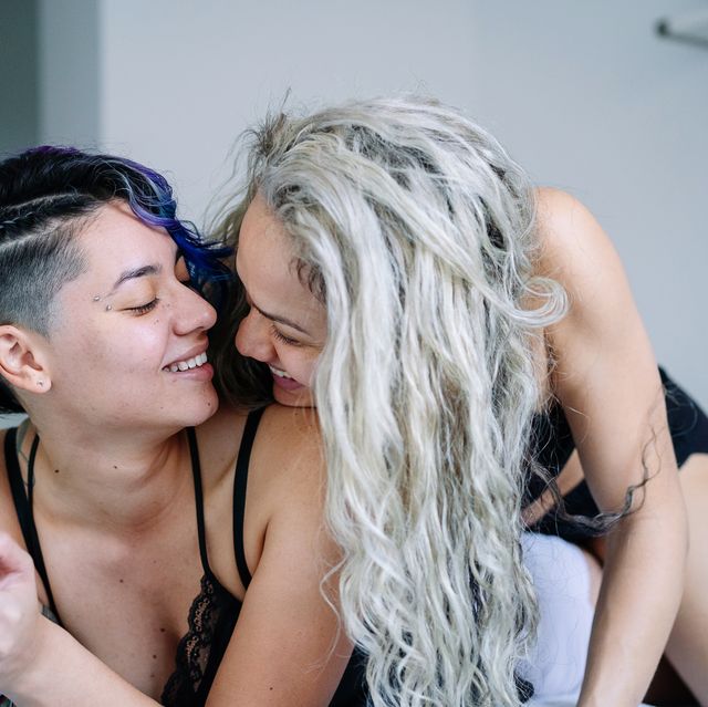 lesbian women in love on intimate bedroom moment wearing pajamas