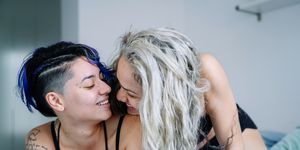 lesbian women in love on intimate bedroom moment wearing pajamas