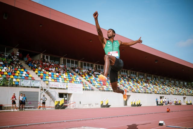 athlete performing a long jump at a sports event
