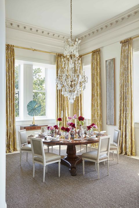 custom chairs are covered in shagreen leather in a corner dining area with a crystal chandelier and flowers on a grandly set table