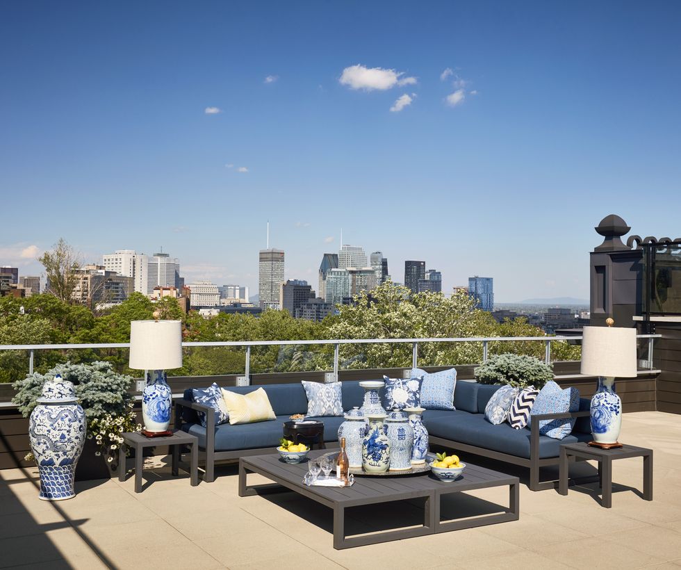 chinese ceramics dress up a rooftop terrace where there is a sectional sofa with pillows in blues and whites