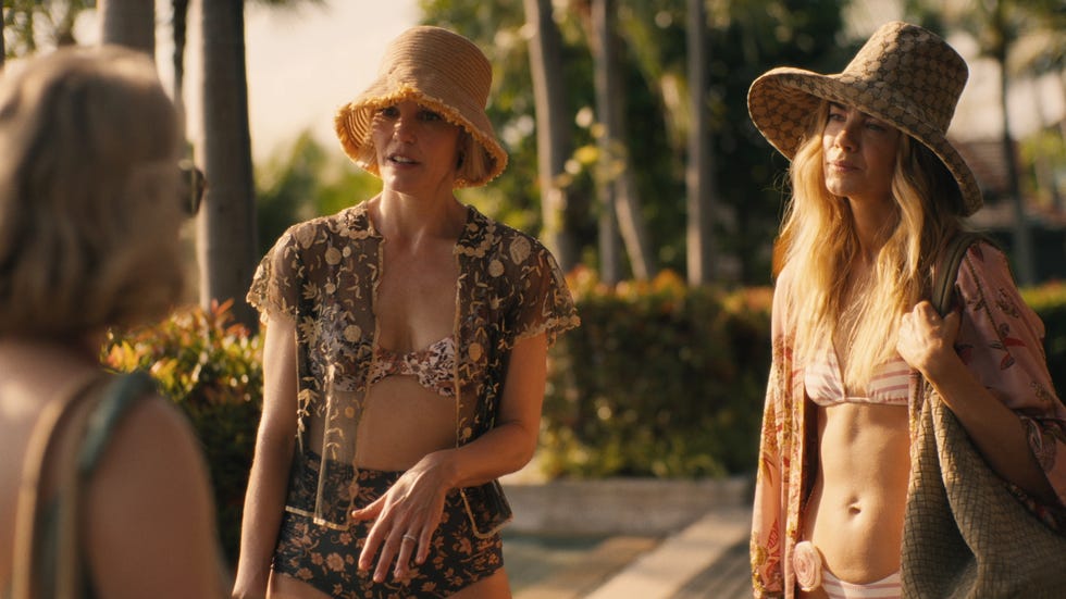 women standing and talking wearing bikinis and hats