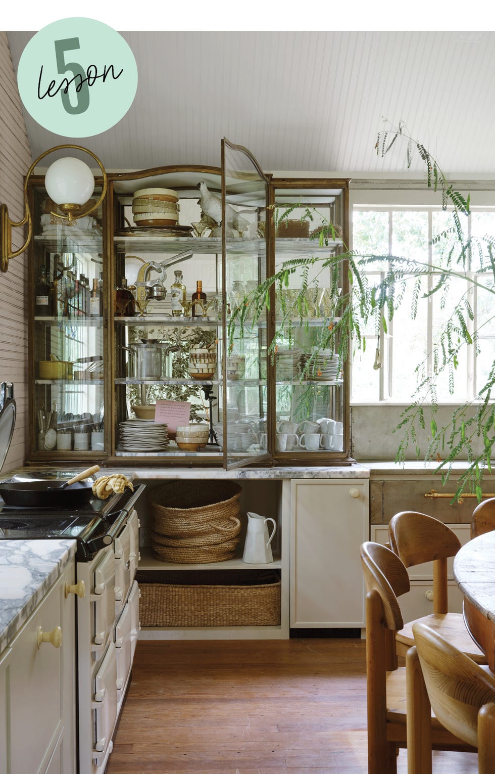 a well organized kitchen with a display cabinet and dining area