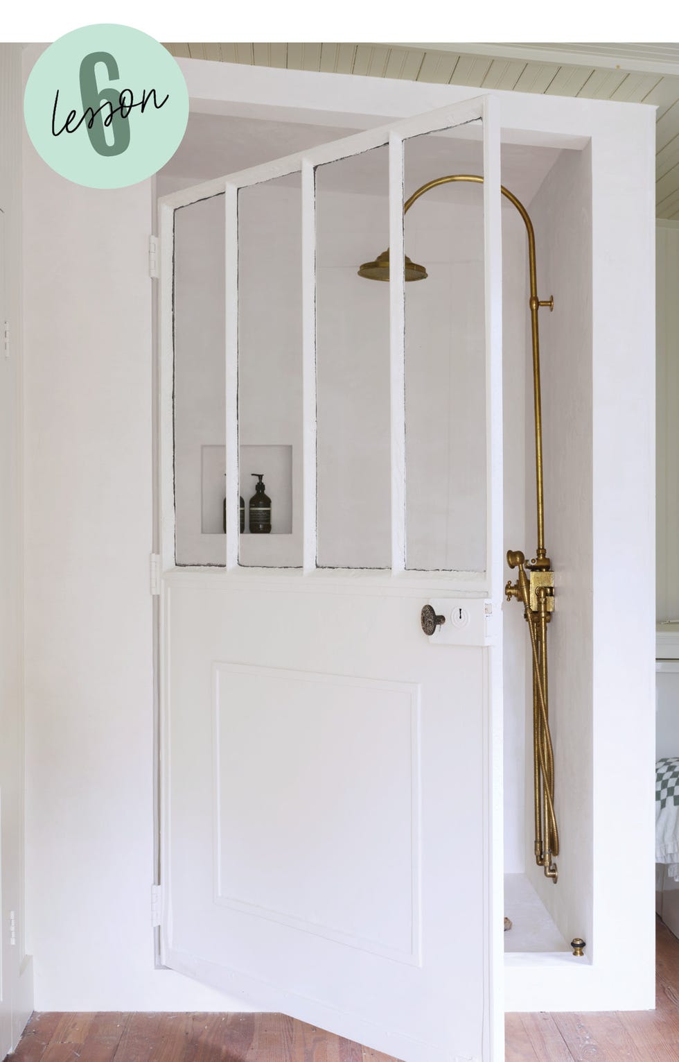 open door leading to a shower area with a bronze showerhead