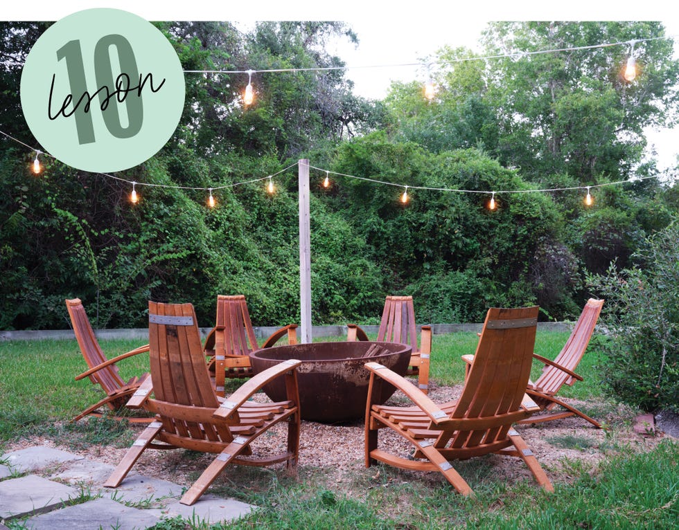 outdoor fire pit area with wooden chairs and string lights