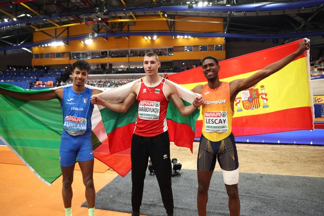 three athletes celebrating their victory with national flags