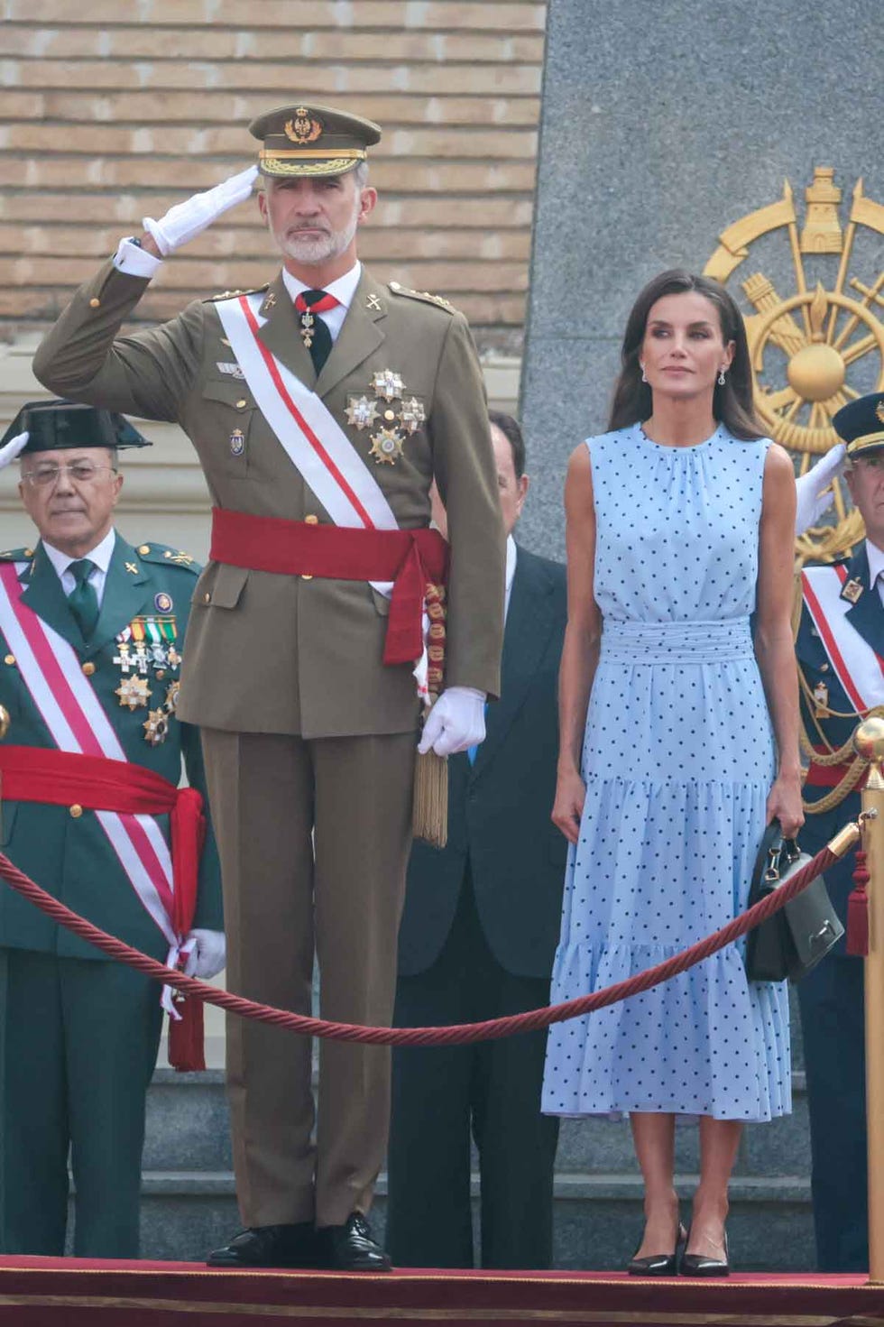 a woman standing next to a man in a military uniform