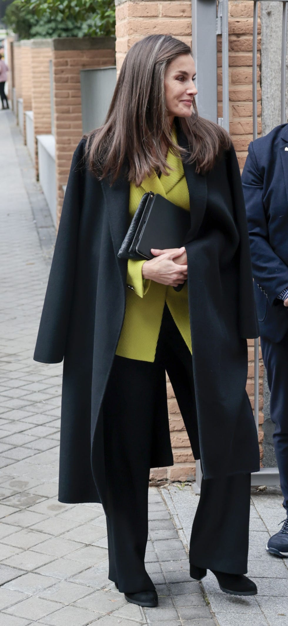 letizia con chaqueta lima,abrigo negro y pantalones negro