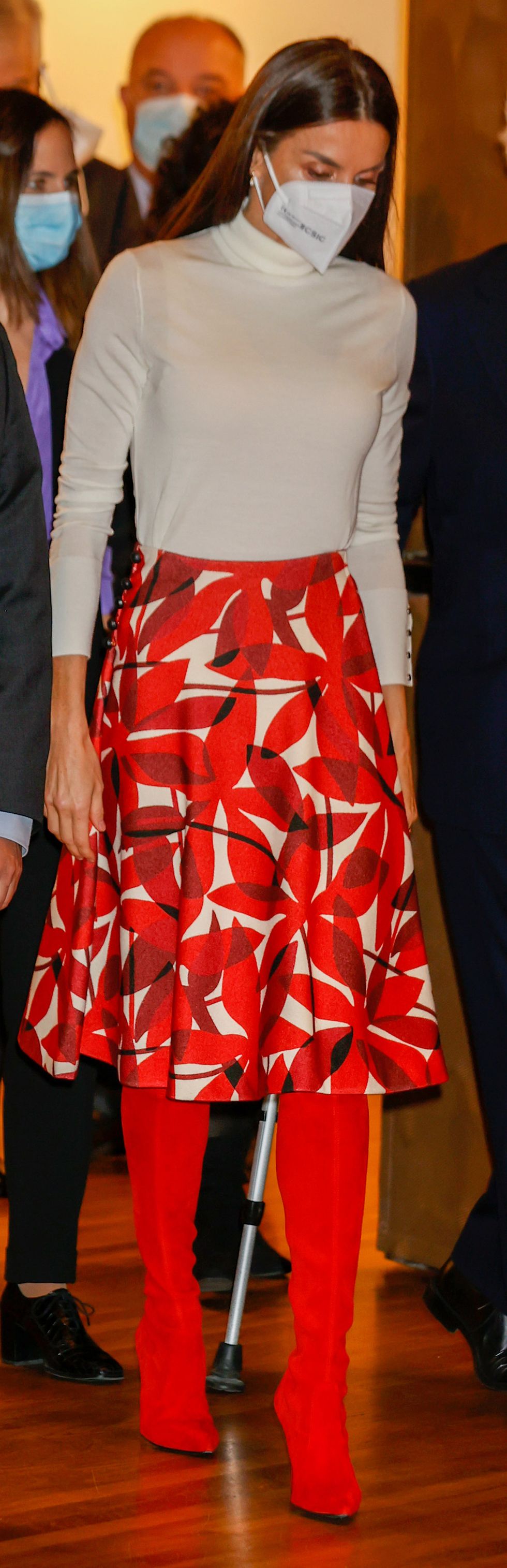 La reina Letizia recicla su falda roja estampada con botas altas