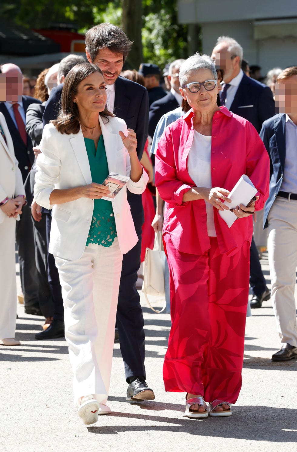 la reina letizia inaugura la feria del libro de madrid 2024 con traje blanco y blusa verde, acompanada de eva orue y el ministro de cultura, ernest urtasun