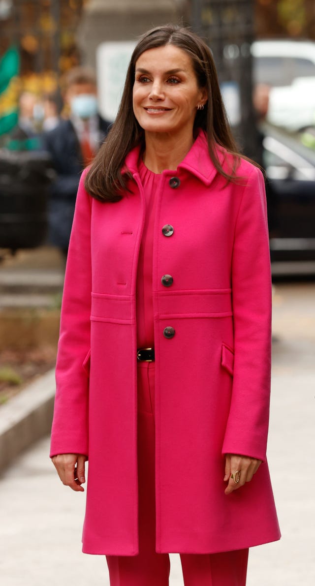 la esposa de felipe vi con abrigo y flusa en color fucsia
