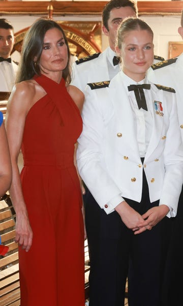 two individuals posing together one in formal attire the other in a red dress