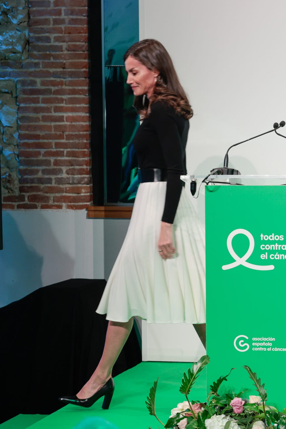 la reina letizia en el acto all against cancer en el día internacional contra el cáncer en madrid, con look en blanco y negro de jersey y falda