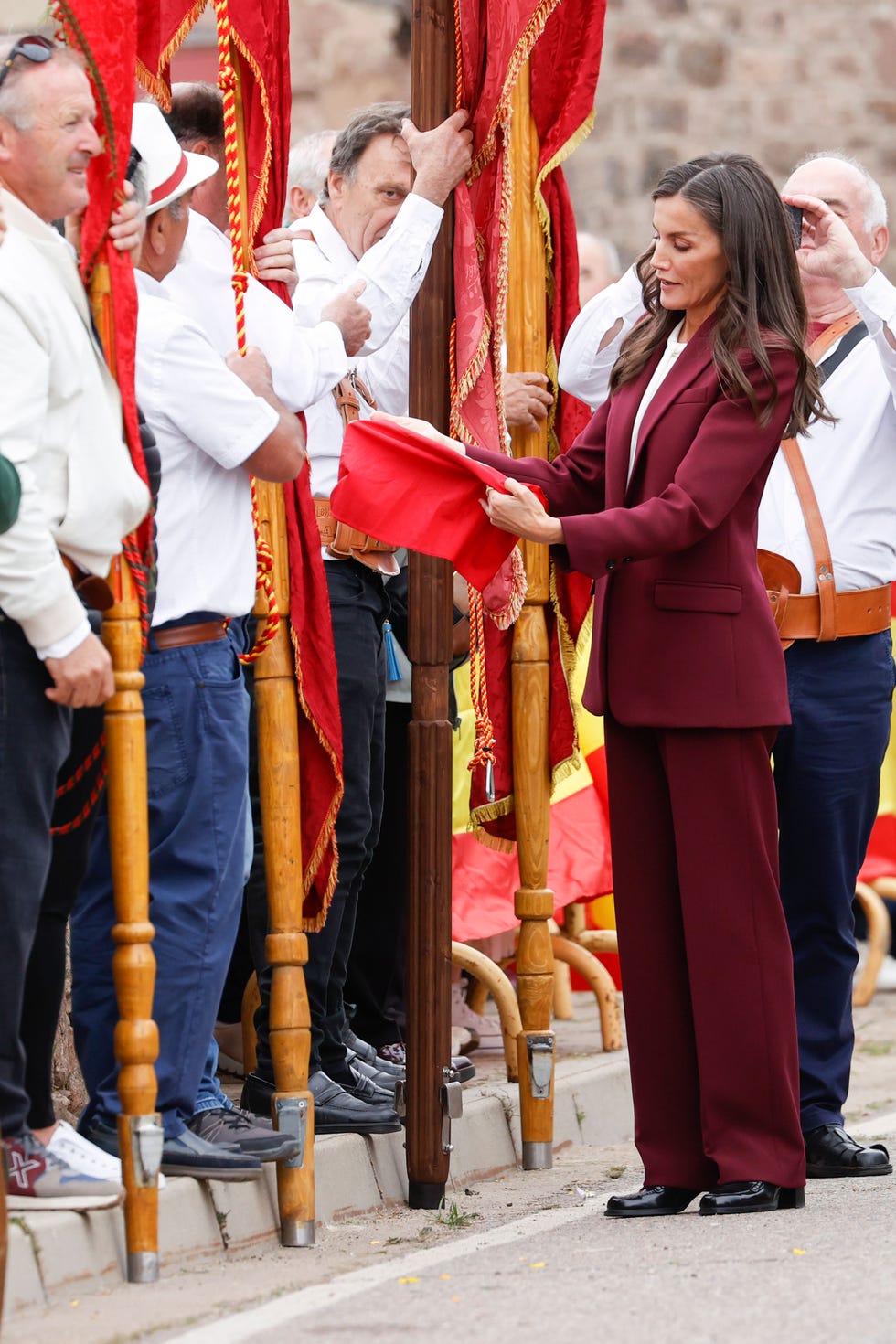Ceremonial event featuring a woman receiving a red cloth from a group of people