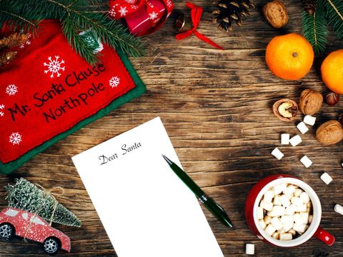 letter to santa claus concept paper on wooden background with cristmas decoration and cup of hot chocolate top view copy space
