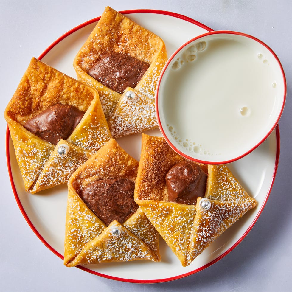 letter shaped pastries filled with chocolate and cinnamon sugar on a plate with milk