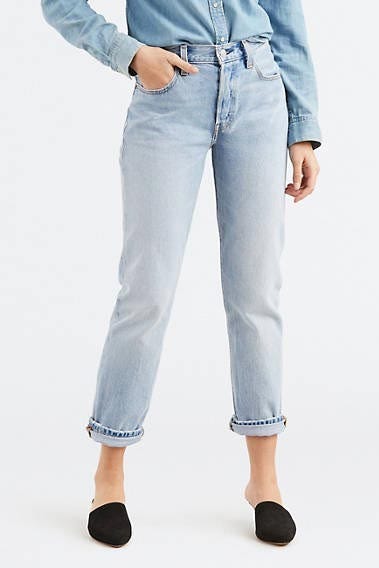 a model shown from the waist down wearing black flats and levis jeans good housekeepings pick for the best sustainable denim