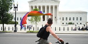 a man waves a rainbow flag as he rides by the us supreme court that released a decision that says federal law protects lgbtq workers from discrimination on june 15, 2020 in washington,dc   the us top court has ruled it illegal to fire workers based on sexual orientation photo by jim watson  afp photo by jim watsonafp via getty images
